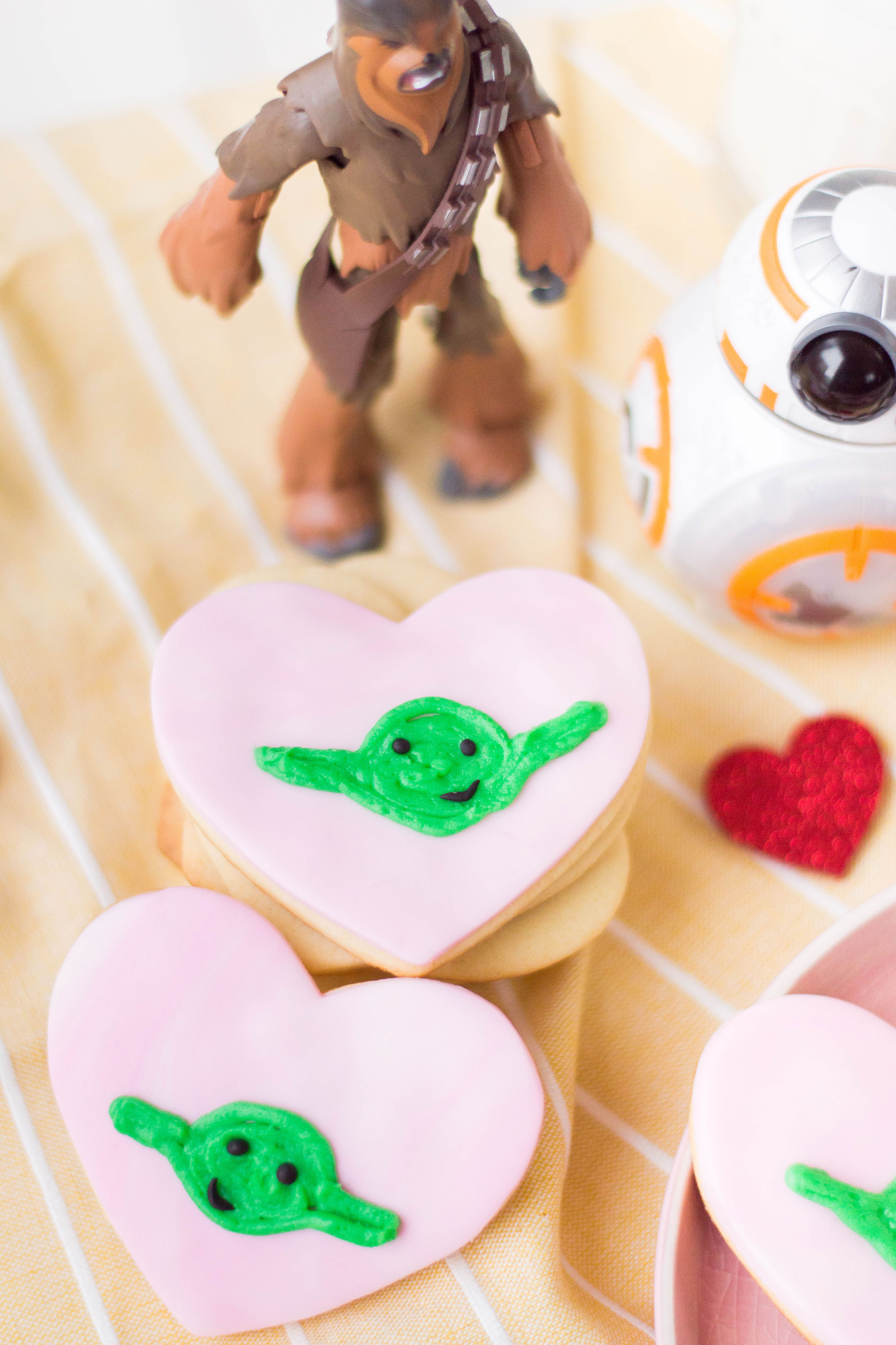 Too cute, these are. Celebrate Valentine's Day with these ultra cute heart-shaped Yoda Sugar Cookies. The force can be romantic, too! #valentinesdayrecipes #starwarscookies